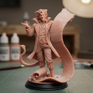 May include: A light peach-colored resin miniature figure of a humanoid character with a pointed tail, wearing a long coat, vest, and boots. The figure stands on a circular black base, holding a long, flowing scroll that curls around the base.