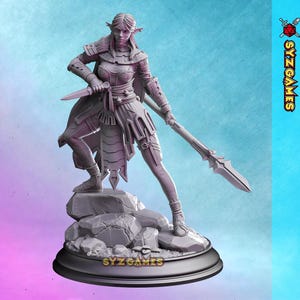 May include: A detailed gray figurine of a female warrior, holding a dagger and a spear. The figure is posed on a rocky base, with intricate armor and clothing details. The base has the text "SYZ GAMES".