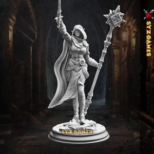 May include: A detailed, gray-toned figurine of a female fantasy character, holding a sword aloft in her right hand and a staff in her left. She wears a hooded cloak and armor, standing on a circular base with the text "SYZ GAMES". The background is a dimly lit corridor.