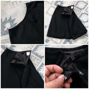 May include: Black skirt with a zipper closure and a black lining. The skirt is made of a thick, textured fabric.