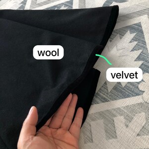 May include: A black fabric swatch with two different textures. The top layer is wool and the bottom layer is velvet.