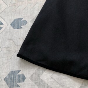 May include: Black fabric with a black trim around the edge.