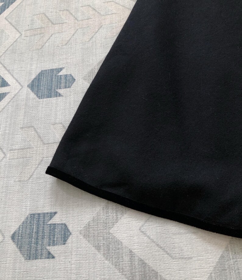 May include: Black fabric with a black trim around the edge.