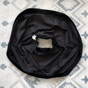 May include: Black circle skirt with a gathered waistband and a smooth, silky fabric.