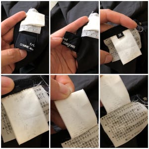 May include: Black Comme des Gar&ccedil;ons jacket with a white label that reads "Comme des Gar&ccedil;ons" and "Tricot" in Japanese. The label also includes care instructions in Japanese. The jacket has a size tag that reads "M".