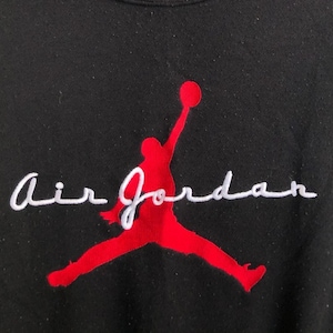 May include: Black sweatshirt with a red silhouette of a basketball player jumping and the text "Air Jordan" in white cursive.