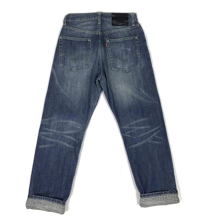 May include: A pair of blue denim jeans with a cuffed hem. The jeans have a faded look and are distressed in places.