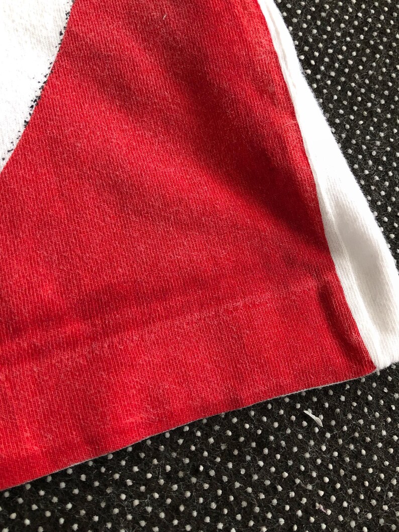 Puede incluir: Primer plano de una tela a rayas rojas y blancas. La tela est&aacute; hecha de un material suave y texturizado.