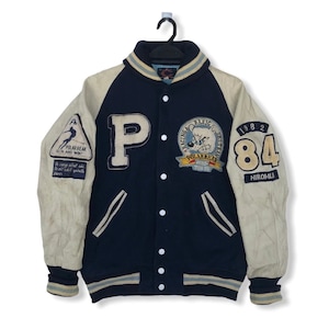 May include: A navy blue and cream varsity jacket with a large "P" on the front, a patch with a cartoon bear and the text "Racing Basic Ski Team Polarbear Tokyo", and a patch on the sleeve with the text "Polar Bear Run and Win!" and the year "1982 84 HIROMLI".