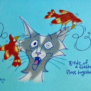 May include: A cartoon illustration of a cat with two birds perched on its ears. The cat has a surprised expression and the birds are red and orange with black markings. The text "Birds of a feather floss together" is written in blue below the cat.