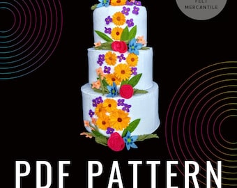 May include: A three-tiered felt cake decorated with felt flowers in shades of yellow, pink, purple, and green. The cake is white and has a "PDF PATTERN" text overlay. The image also includes a logo for "FELT MERCANTILE" with a graphic of two bottles and a basket.