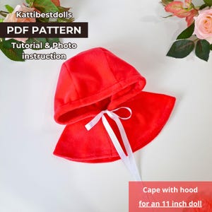 Könnte beinhalten: Rote Kapuze mit weißem Schleifenband, entworfen für eine 28 cm Puppe. Die Kapuze ist aus weichem Stoff und hat ein schlichtes, klassisches Design. PDF-Muster, Anleitung und Foto-Anweisungen sind enthalten.