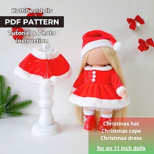 Könnte beinhalten: PDF-Muster für ein Weihnachtsoutfit für eine 28 cm große Puppe. Das Outfit beinhaltet ein rotes Kleid mit weißen Verzierungen, einen roten Umhang mit weißen Verzierungen und eine rote Weihnachtsmütze. Die Puppe ist nicht im Lieferumfang enthalten.