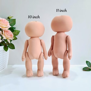 May include: Two unpainted doll bodies made of fabric, one is 10 inches tall and the other is 11 inches tall.