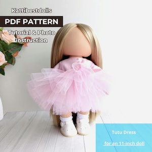 May include: A doll wearing a pink tutu dress, with long blonde hair and white shoes. The doll is approximately 11 inches tall. The image includes text that reads "PDF PATTERN" and "Tutu Dress for an 11-inch doll."