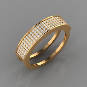 May include: A gold-colored ring with a band covered in small, clear gemstones. The ring has a double-band design and a rectangular top section, also covered in gemstones. The ring is set against a gray background.