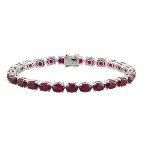 May include: A silver-toned bracelet featuring oval-cut, deep red gemstones. The gemstones are set closely together, creating a continuous line of color. The bracelet has a secure clasp and is designed for everyday wear or special occasions.