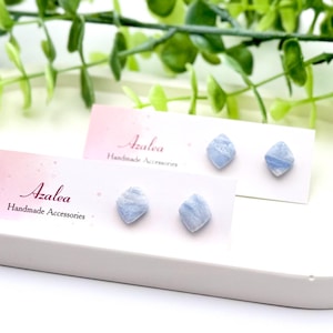 May include: Two pairs of blue gemstone earrings displayed on white cards with the text "Azalea Handmade Accessories".