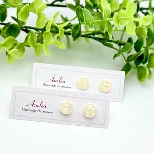 Peut inclure: Deux paires de boucles d'oreilles en perles blanches présentées sur une carte blanche avec le texte "Azalea Handmade Accessories".