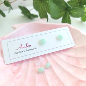 May include: A pair of light green gemstone earrings on a white card with the text "Azalea Handmade Accessories".