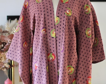 May include: A mauve Japanese kimono with a geometric pattern and colourful embroidered flowers. The kimono is displayed on a mannequin.