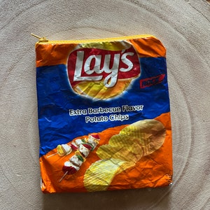 May include: A blue and orange Lay's potato chip bag repurposed into a zippered pouch. The bag features the Lay's logo, the text "Extra Barbecue Flavor Potato Chips", and a picture of potato chips.