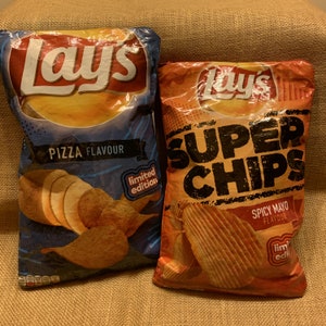 Può includere: Due sacchetti di patatine fritte Lay's. Il sacchetto a sinistra è blu e presenta un logo Lay's rosso e il testo "Pizza Flavour" e "Limited Edition". Il sacchetto a destra è arancione e presenta un logo Lay's rosso e il testo "Super Chips" e "Spicy Mayo Flavour" e "Limited Edition".