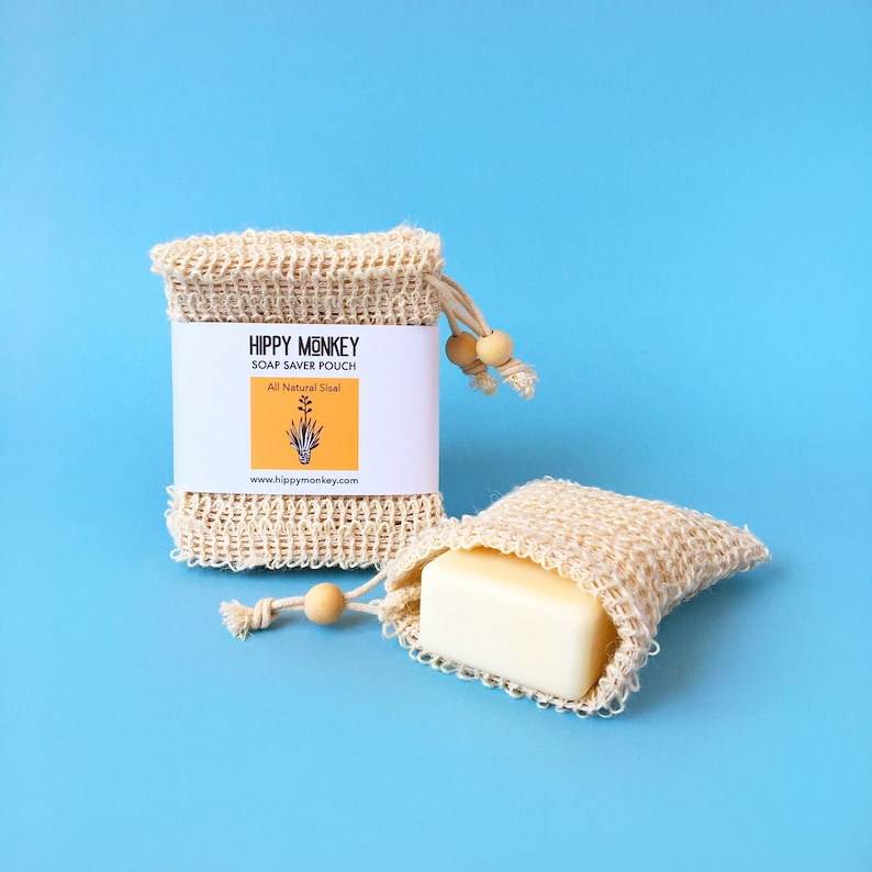 May include: Two natural fiber soap saver pouches with a bar of soap in one. The pouches are made of a natural material and have a drawstring closure. The label on the pouch reads "Hippy Monkey Soap Saver Pouch All Natural Sisal www.hippymonkey.com"