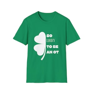May include: Green t-shirt with a white four-leaf clover graphic. The text "SO LUCKY TO BE AN OT" is printed in white. The shirt is a crew neck style.