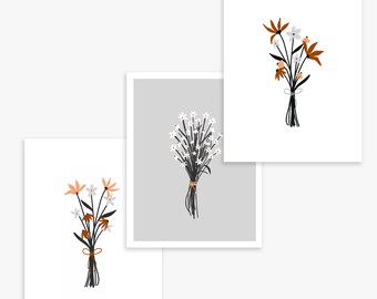 Könnte beinhalten: Drei Kunstdrucke mit stilisierten Blumensträußen. Die Sträuße zeigen weiße, orangefarbene und braune Blumen mit schwarzen Stielen, die mit Bindfaden gebunden sind. Ein Druck hat einen grauen Hintergrund, die anderen sind auf weißem Grund.