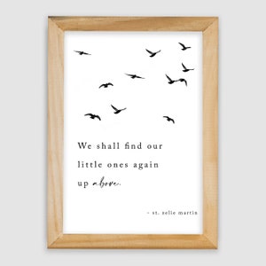 May include: A framed print with a quote about finding loved ones again in the afterlife. The quote reads "We shall find our little ones again up above." and is attributed to "st. zelic martin". The print features a simple design with black silhouettes of birds flying upwards.