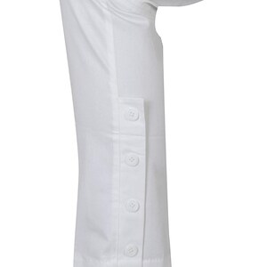 May include: White pants with a button detail on the side of the leg.