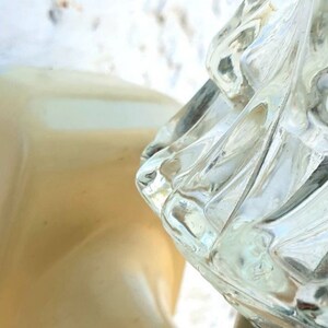 May include: A close-up of a white light fixture with a clear glass shade. The glass shade has a textured, geometric design. The light fixture is labeled "Targetti".