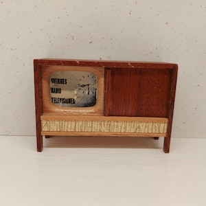 Puede incluir: Un televisor de juguete de madera vintage con un gabinete de madera marrón y una pantalla que dice "Sveriges Radio Televisonen".