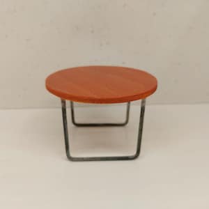 May include: A small round table with a brown wooden top and a black metal frame.