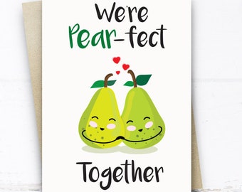 May include: A white card with the text "We're pear-fect together" and a cartoon image of two pears with faces, hugging each other.  There are small red hearts above the pears.