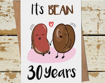 May include: A white card with the text "It's Bean 30 years" and a cartoon image of two beans holding hands. The beans are red and brown and have happy faces.