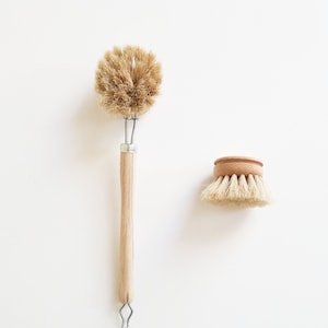 Puede incluir: Dos cepillos para platos de cerdas naturales con mangos de madera. Un cepillo tiene un mango largo y el otro es un cepillo redondo más pequeño.