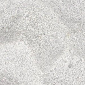May include: Close-up of a white, grainy surface with a slightly textured appearance. The surface is smooth and uniform, with a subtle sheen.