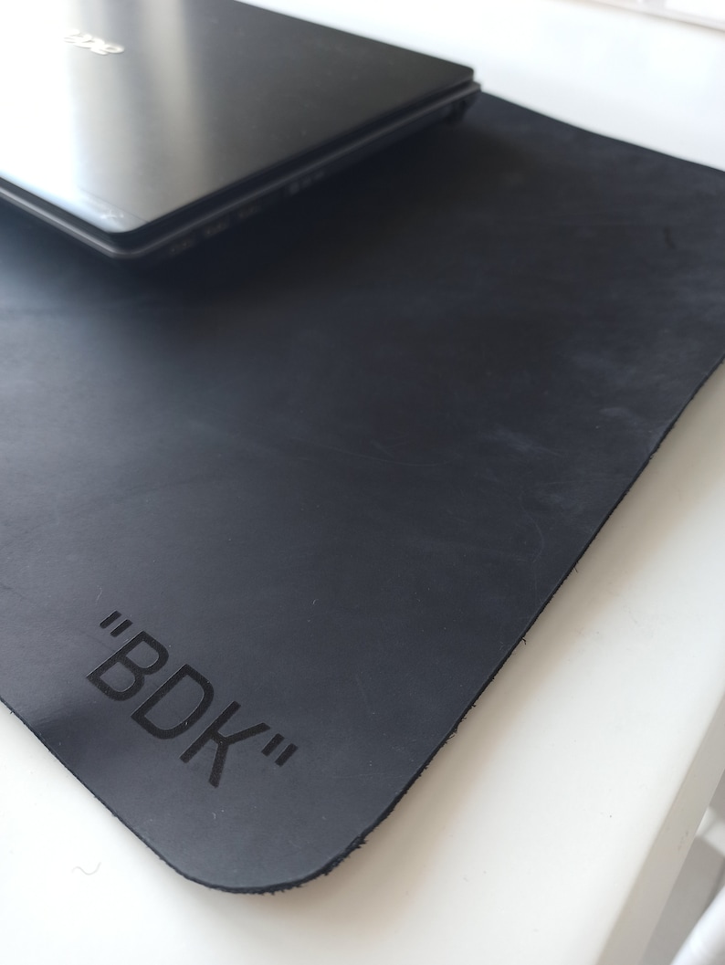 May include: Black leather desk mat with the text "BDK" embossed in the center.