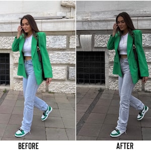 May include: A woman wearing a green blazer, light blue jeans, and green and white sneakers. She is standing on a sidewalk in front of a building.