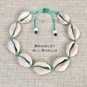 May include: A bracelet made of cowrie shells strung on a green cord with white and green beads. The bracelet is adjustable with a sliding knot. The text "BRACELET ALL SHELLS" is printed on a white background.