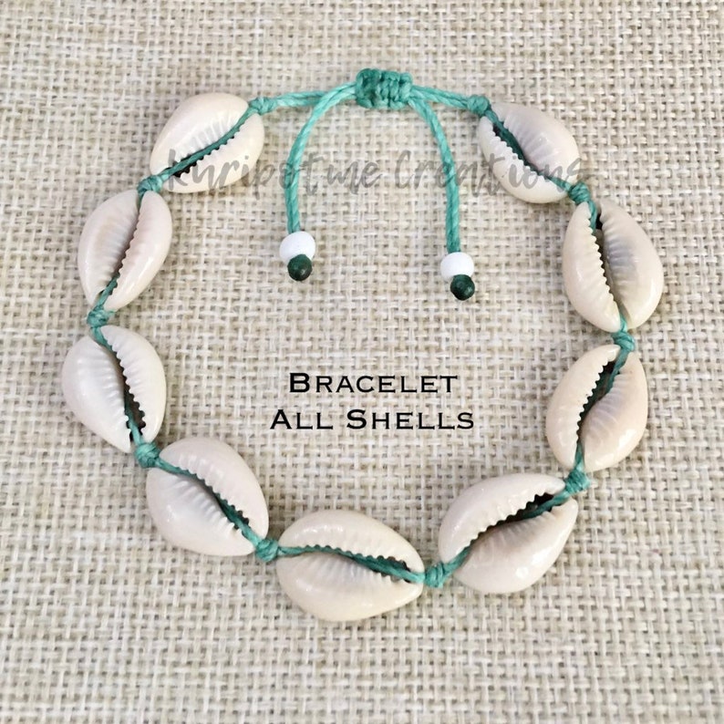 May include: A bracelet made of cowrie shells strung on a green cord with white and green beads. The bracelet is adjustable with a sliding knot. The text "BRACELET ALL SHELLS" is printed on a white background.