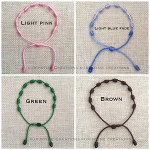 May include: Four knotted bracelets in different colors: light pink, light blue fade, green, and brown. Each bracelet has a knotted design and a sliding knot for adjusting the size.