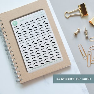 May include: A sheet of 108 hand-drawn eyebrow sticker decals. The stickers are black and white and are arranged in a grid pattern on a white background. The sheet is labelled "eyebrows hand drawn sticker sheet" and "scotia paper stationery & gifts".
