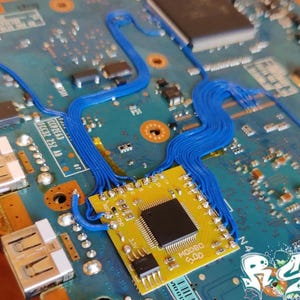 K&ouml;nnte beinhalten: Nahaufnahme einer blauen Leiterplatte mit einem gelben Chip mit der Aufschrift "MOORO 5.00". Blaue Dr&auml;hte sind &uuml;ber die Platine gef&uuml;hrt.