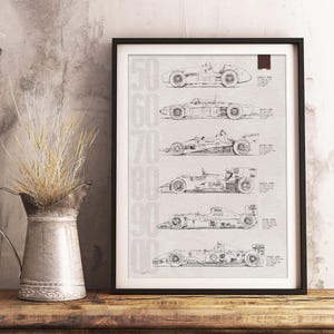 May include: Framed black and white print featuring detailed line drawings of Formula 1 race cars from the 1950s to the 1990s. The print includes the years 50, 60, 70, 80, and 90 in a vertical column on the left side. The print is displayed on a wooden surface.