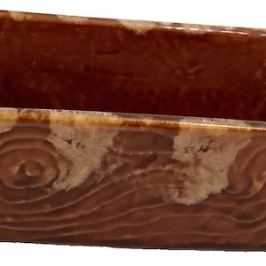 May include: A rectangular brown ceramic planter with a woodgrain pattern. The planter has a light brown glaze with a swirl design.