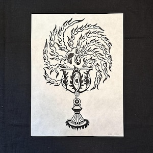 May include: Black and white line art print of a skull inside a chalice with flames around it. The print is signed "MNR 2014".