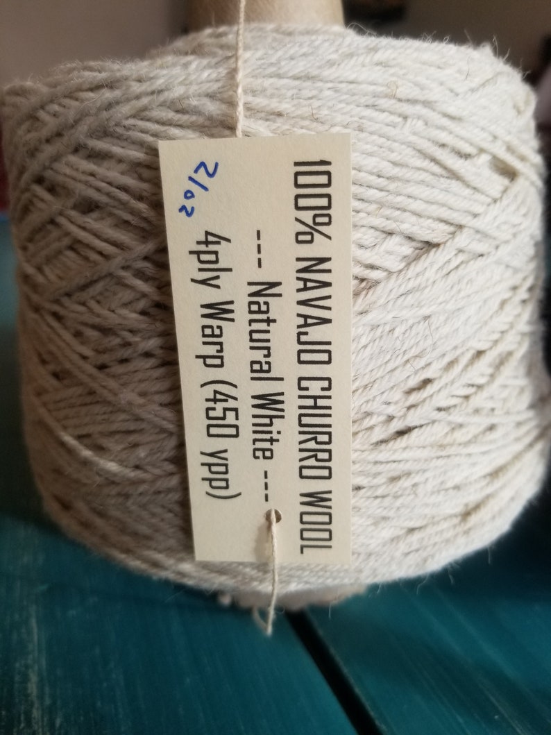 May include: A skein of 100% Navajo Churro wool yarn in natural white. The label reads "100% Navajo Churro Wool -- Natural White -- 2/2 4ply Warp (450 ypp)".